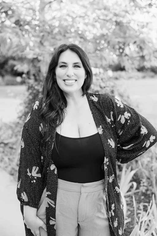 Roey Mizrahi smiling in a floral jacket, in black and white.